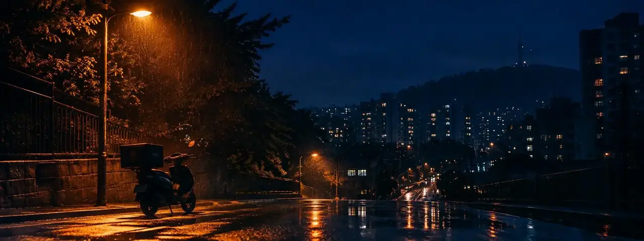 雨夜城市街道，暖黄路灯下停着一辆外卖电动车